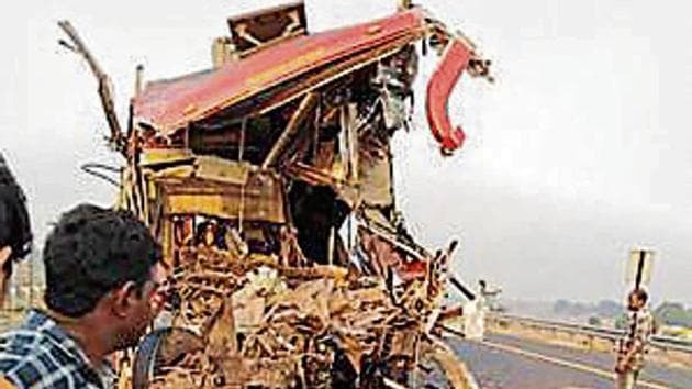 On-lookers gather near the accident site where a bus rammed into a truck on the Agra-Lucknow expressway. (PTI Photo)