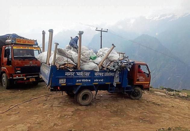 Workers of Joshimath civic body clean up the waste generated after the luxury wedding in Auli.(HT Photo)