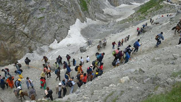 Pilgrims trek to the holy cave shrine of Amarnath, in Baltal, Jammu and Kashmir on Monday.(PTI)