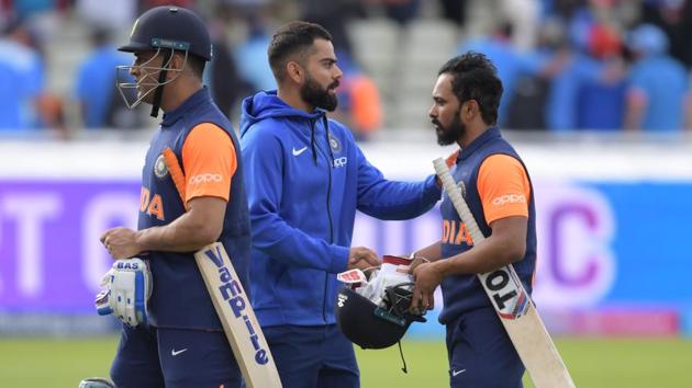 India's captain Virat Kohli (C) greets his players Mahendra Singh Dhoni (L) and Kedar Jadhav (R) as they walk off the field after defeat in the 2019 Cricket World Cup group stage match between England and India at Edgbaston in Birmingham, central England, on June 30, 2019.(AFP)