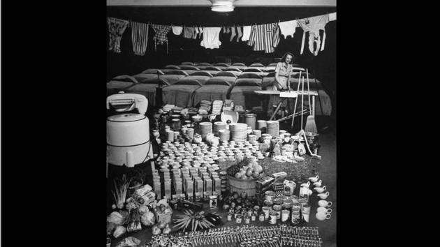 Housewife Marjorie McWeeney ironing amidst a symbolic display of her week's housework at Bloomingdale's store-- 35 beds to be made, 750 items of glass & china, 400 pieces of silverware to wash, 174 lbs of food to prepare, some of 250 pieces of laundry on a line and a ringer washing machine. Nina Leen’s photograph from “American Woman’s Dilemma,” LIFE, June 16, 1947. (© LIFE Picture Collection, Meredith Corporation) Housewife Marjorie McWeeney ironing amidst a symbolic display of her week's housework at Bloomingdale's store-- 35 beds to be made, 750 items of glass & china, 400 pieces of silverware to wash, 174 lbs of food to prepare, some of 250 pieces of laundry on a line and a ringer washing machine. Nina Leen’s photograph from “American Woman’s Dilemma,” LIFE, June 16, 1947. (© LIFE Picture Collection, Meredith Corporation)