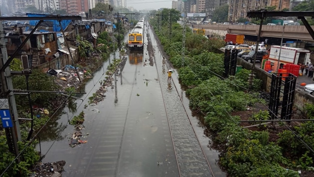 Train services on Mumbai’s colonial-era rail network, a lifeline for the city’s population, were reduced due to waterlogged tracks while motorists were seen pushing cars through flooded streets.(Photo: Kunal Patil/ Hindustan Times)