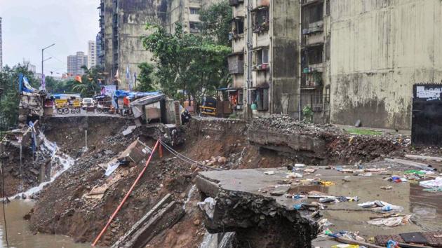 A road caves in following heavy monsoon rains, at Sangharsh Nagar in Mumbai.(PTI)