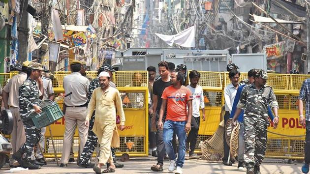 Residents and defence personnel seen near closed shops after clashes broke out over a parking issue, at Lal Kuan Bazar, Hauz Qazi, in New Delhi, India.(Sanjeev Verma/ Hindustan Times)