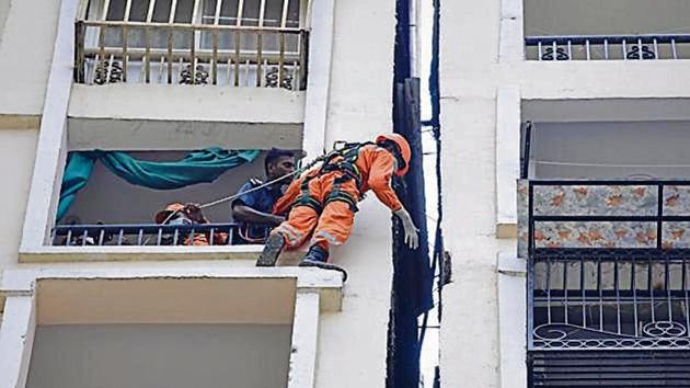 Members of the National Disaster Response Force (NDRF) during the operation to pull down the body of a woman who mysteriously stuck and died in one foot shaft between two towers of Amrapali Silicon City, Sector 76, in Noida.(Sunil Ghosh / Hindustan Times)