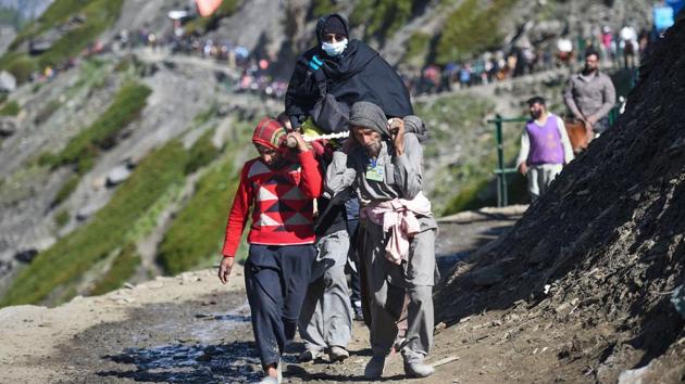 A woman devotee is carried on a palanquin as pilgrims move towards the cave shrine. Old people and children rode ponies on Monday. In 2000, gunmen struck in the Pahalgam area and killed 30 people, including some local porters who carry the pilgrims’ baggage on the mountain path. (S Irfan / PTI) A woman devotee is carried on a palanquin as pilgrims move towards the cave shrine. Old people and children rode ponies on Monday. In 2000, gunmen struck in the Pahalgam area and killed 30 people, including some local porters who carry the pilgrims’ baggage on the mountain path. (S Irfan / PTI)