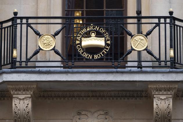 The “Sign of the Golden Bottle” sits on balcony railings above the entrance to C. Hoare & Co. “Our seventh generation got way too wealthy and burnt through a fantastic fortune,” “There are two things that can destroy a family business: the business and the family, and they both have to be kept in order,” said Alexander Hoare. (Bryn Colton / Bloomberg)