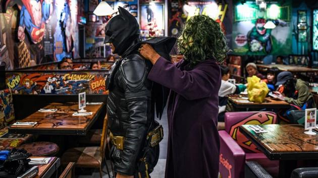 Malaysian cosplayers dressed as Batman and The Joker prepare at a cafe during the DC Super Heroes Day to mark the 80th anniversary of Batman in Genting Highlands resort outside of Kuala Lumpur. (Mohd Rasfan / AFP) Malaysian cosplayers dressed as Batman and The Joker prepare at a cafe during the DC Super Heroes Day to mark the 80th anniversary of Batman in Genting Highlands resort outside of Kuala Lumpur. (Mohd Rasfan / AFP)