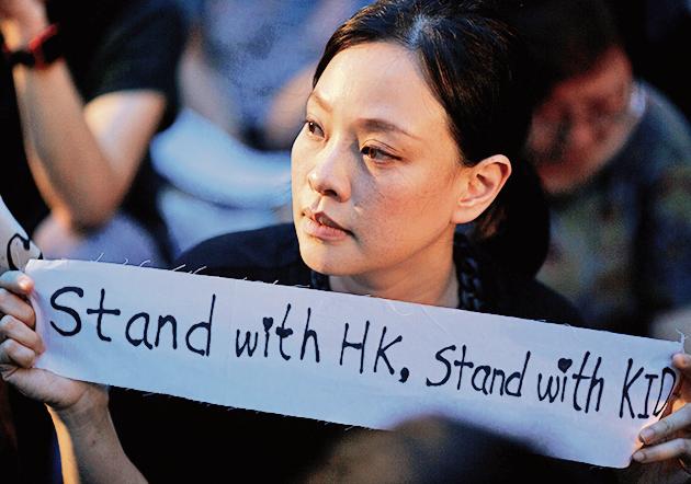 A woman holds a placard during a gathering of Hong Kong mothers to show their support for the city's young pro-democracy protesters in Hong Kong, China, July 5, 2019(REUTERS) A woman holds a placard during a gathering of Hong Kong mothers to show their support for the city's young pro-democracy protesters in Hong Kong, China, July 5, 2019(REUTERS)