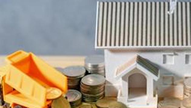 House, crane and construction truck models with gold coins spilling on wooden table. Real estate development or property investment. Home mortgage loan rate. Construction industry business concept(PHOTO FOR REPRESENTATION PURPOSE ONLY)