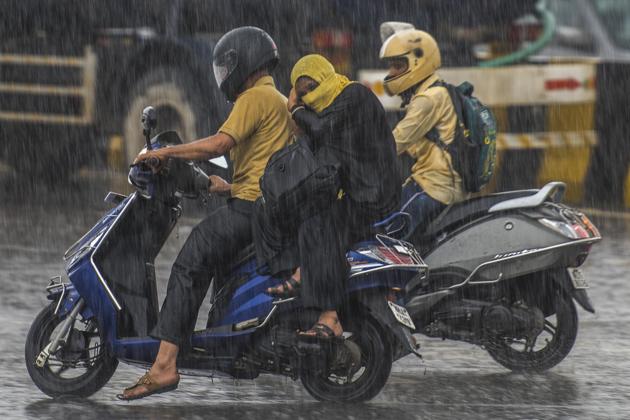 Bikers brave the rain at Chheda Nagar on Saturday.(Pratik Chorge/HT Photo)