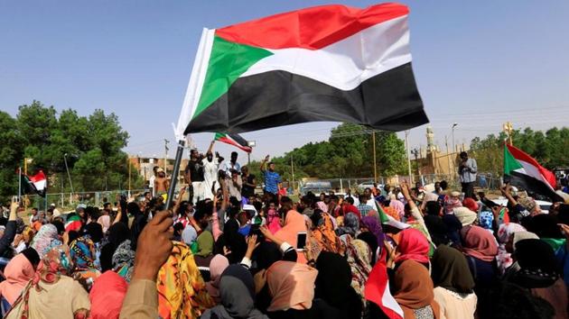 Sudanese people chant slogans and wave their national flag as they celebrate, after Sudan's ruling military council and a coalition of opposition and protest groups reached an agreement to share power during a transition period leading to elections, along the streets of Khartoum, Sudan.(REUTERS)
