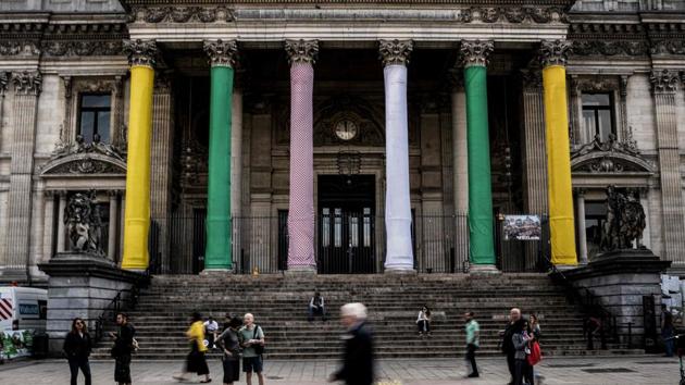 People pass by Brussels stock exchange building Beurs - Bourse with its columns wrapped with the colours of cycling jerseys, overall leader’s yellow, best sprinter’s green, best climber’s polka dot and best young white one in Brussels centre. (Jeff Pachoud / AFP) People pass by Brussels stock exchange building Beurs - Bourse with its columns wrapped with the colours of cycling jerseys, overall leader’s yellow, best sprinter’s green, best climber’s polka dot and best young white one in Brussels centre. (Jeff Pachoud / AFP)