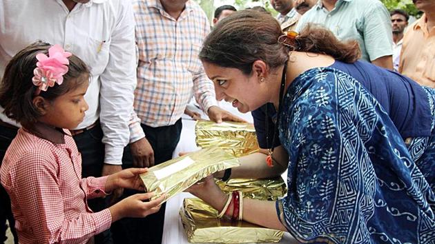 Union Women and Child Development Minister Smriti Irani distributes book to the student at a government school during her visit in Amethi on Saturday.(ANI Photo) Union Women and Child Development Minister Smriti Irani distributes book to the student at a government school during her visit in Amethi on Saturday.(ANI Photo)
