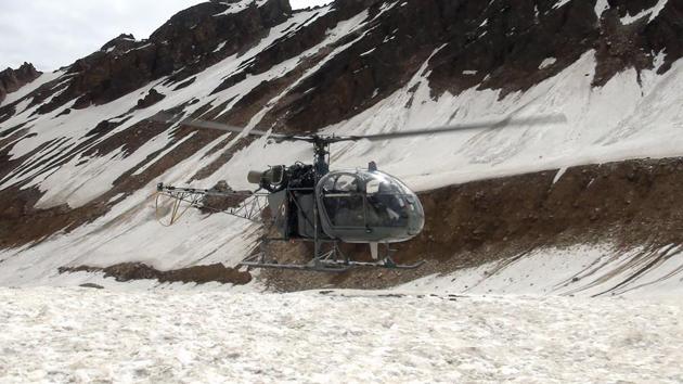 A helicopter is seen monitoring the mountain peak to retrieve the bodies of mountaineers from Nanda Devi at base camp before carrying the remains down to Pithoragarh, Uttarakhand. (Indo Tibetan Border Patrol (ITBP) / AFP)