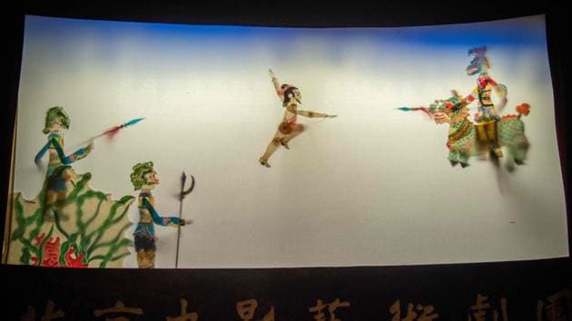 Puppets are seen on a shadow theatre stage during a performance by the Beijing Shadow Show Troupe at a school in Beijing.(AFP)