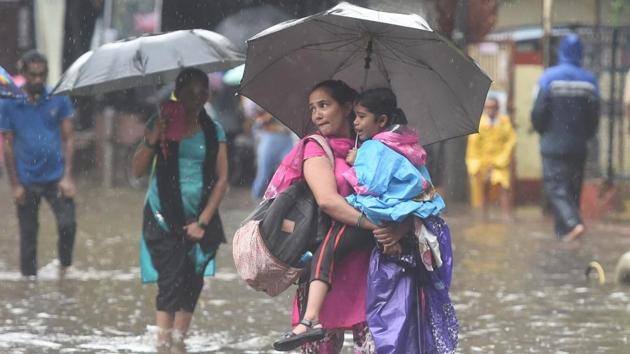 Commuters wade through a waterlogged street, following heavy Monsoon rain in Mumbai. According to the weather bureau, intense rain was recorded in the central parts of Mumbai and suburbs at 20mm, considered as moderate, in less than two hours due to a strong cloud patch. (Shashank Parade / PTI) Commuters wade through a waterlogged street, following heavy Monsoon rain in Mumbai. According to the weather bureau, intense rain was recorded in the central parts of Mumbai and suburbs at 20mm, considered as moderate, in less than two hours due to a strong cloud patch. (Shashank Parade / PTI)