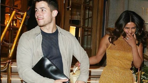 Nick Jonas seen carrying a leather clutch at a Dior fashion show.(Priyanka Chopra Online/Instagram)