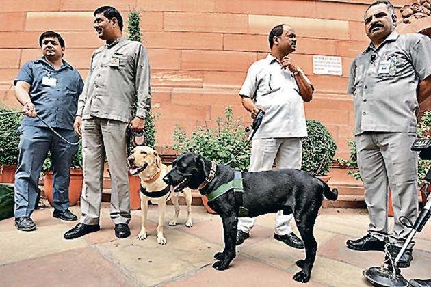 Security personnel and sniffer dogs stand to check the budget papers that are unloaded from a truck, at Parliament House, in New Delhi, India, on Friday, July 5, 2019. (Photo by Raj K Raj/Hindustan Times)