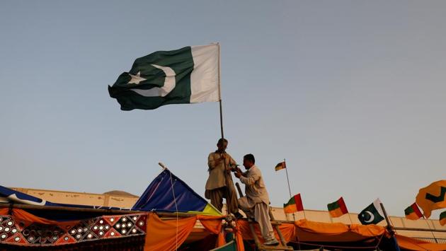 Men install Pakistan's national flag on a stall. Many Hazaras have joined the armed forces in Pakistan, where the community’s past and future will stay rooted despite any violence, said another martial arts expert, Mubarak Ali Shan. “We want to serve Pakistan and despite suffering tragedies and incidents, our love for peace has not diminished,” he added. (Akhtar Soomro / REUTERS) Men install Pakistan's national flag on a stall. Many Hazaras have joined the armed forces in Pakistan, where the community’s past and future will stay rooted despite any violence, said another martial arts expert, Mubarak Ali Shan. “We want to serve Pakistan and despite suffering tragedies and incidents, our love for peace has not diminished,” he added. (Akhtar Soomro / REUTERS)