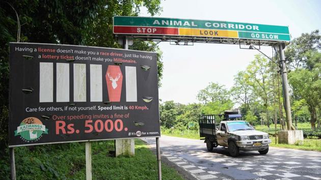 Vehicles drive past a signboard for the vehicles speed limit on National Highway 37 adjoining Kaziranga National Park. The 850-square-kilometre (330-square-mile) park, created in 1908 after the wife of the British viceroy visited and complained there were no rhinos, is also home to tigers, elephants and panthers, all under threat from poaching. (Biju Boro / AFP) 