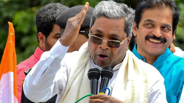 Former prime minister and Janatha Dal (Secular) Supremo, H.D. Deve Gowda (R) and Congress leader K.C. Venugopal (C behind) look on as former chief minister Siddaramaiah (L) speaks to supporters during a demonstration staged by Karnataka Congress and Janatha Dal (Secular) coalition government against the Bharatiya Janatha Party and its alleged horse trading, in Bangalore on July 10, 2019. - The one-year-old coalition government of COngress and Janatha Dal in Karnataka has been fighting for survival after 14 of its MLAs have submitted resignations leading to a political turmoil in the state. (Photo by MANJUNATH KIRAN / AFP)(AFP)