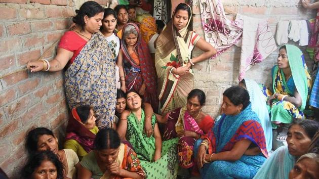 Family members and relatives mourn the death of a kin who died in a wall collapse in Patna.(PTI Photo)