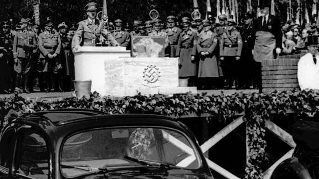 German Nazi leader Adolf Hitler speaks at the opening ceremony of the Volkswagen car factory in Fallersleben, Lower Saxony, Germany, on May 26, 1938. The car’s original design — a rounded silhouette with seating for four or five, nearly vertical windshield and the air-cooled engine in the rear — can be traced back to Austrian engineer Ferdinand Porsche, who was hired to fulfill Hitler’s project for a “people’s car.” (AP) German Nazi leader Adolf Hitler speaks at the opening ceremony of the Volkswagen car factory in Fallersleben, Lower Saxony, Germany, on May 26, 1938. The car’s original design — a rounded silhouette with seating for four or five, nearly vertical windshield and the air-cooled engine in the rear — can be traced back to Austrian engineer Ferdinand Porsche, who was hired to fulfill Hitler’s project for a “people’s car.” (AP)