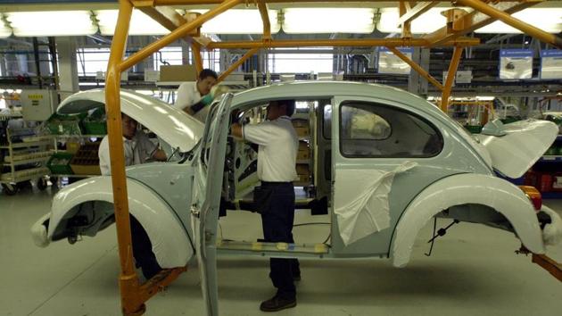 Volkswagen employees work in the assembly plant of the Volkswagen sedan ‘last edition,’ at the VW plant in Puebla, 65 miles (105 kms) southeast of Mexico City, on July 21, 2003. It is here that the company will stop producing the cult classic bug on July 30th. (Jose Luis Magana / AP) Volkswagen employees work in the assembly plant of the Volkswagen sedan ‘last edition,’ at the VW plant in Puebla, 65 miles (105 kms) southeast of Mexico City, on July 21, 2003. It is here that the company will stop producing the cult classic bug on July 30th. (Jose Luis Magana / AP)