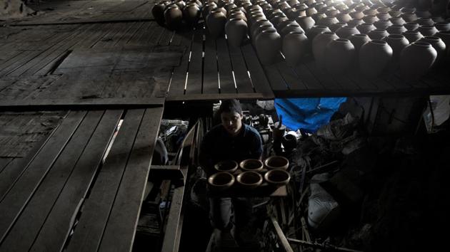 Thousands of unsold clay bowls, pots, vases and jugs sit in the yard of the Atallah pottery workshop. On a recent day, three employees shaped clay on the wheel, while two others mixed mud. Khairi Atallah, the pottery maker, said this is all that remains of the 50 workers he once employed. “The income is no longer enough to get by,” he said. (Khalil Hamra / AP)