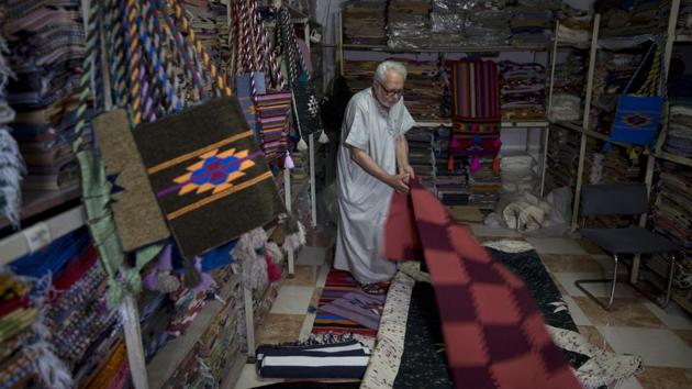 Palestinian Mahmoud al-Sawwaf, the owner of a traditional carpets factory, displays his products. He believes he is the last weaver in Gaza. With the territory closed to tourists, international aid workers are the only people keeping him afloat. Cheaper straw mats have flooded Gaza, and local residents can’t afford his handmade carpets. But the foreigners still buy them. “Even at this age I continue to work,” he said. “I will not give up and quit.” (Khalil Hamra / AP)