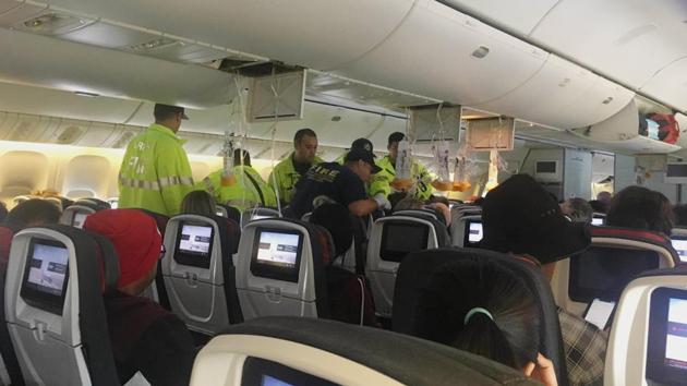 In this photo provided by Hurricane Fall, responders treat a passenger on an Air Canada flight to Australia that was diverted and landed at Daniel K. Inouye International Airport in Honolulu on Thursday, July 11, 2019. The flight from Vancouver to Sydney encountered "un-forecasted and sudden turbulence," about two hours past Hawaii when the plane diverted to Honolulu, Air Canada spokeswoman Angela Mah said in a statement. (Tim Tricky/Hurricane Fall via AP)