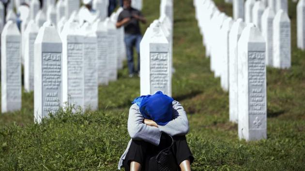 A woman rests at the memorial cemetery, prior to the funeral in Potocari, near Srebrenica, Bosnia. The remains of 33 victims of the Srebrenica massacre will be buried 24 years after Serb troops overran the eastern Bosnian Muslim enclave of Srebrenica and executed some 8,000 Muslim men and boys, which international courts have labelled as an act of genocide. (Darko Bandic / AP)