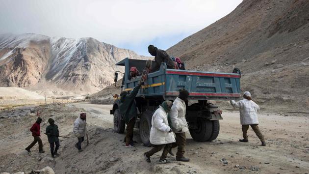 Each morning the group of 13 men hop on a truck to reach the work site after a breakfast of tea and bread. They return to their basic housing tents after sunset and have a meal of rice and lentils. (Xavier Galiana / AFP) Each morning the group of 13 men hop on a truck to reach the work site after a breakfast of tea and bread. They return to their basic housing tents after sunset and have a meal of rice and lentils. (Xavier Galiana / AFP)