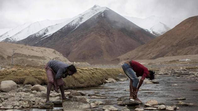 Raju Dheri and Surinder Tudu wash in a river next to their campsite after a day’s work. They have been hired for four months in the Tangtse district of Ladakh, where blizzards can rage throughout the year, to ensure that the key tourist route to the picturesque Nubra Valley and Pangong Lake is in good condition. (Xavier Galiana / AFP) Raju Dheri and Surinder Tudu wash in a river next to their campsite after a day’s work. They have been hired for four months in the Tangtse district of Ladakh, where blizzards can rage throughout the year, to ensure that the key tourist route to the picturesque Nubra Valley and Pangong Lake is in good condition. (Xavier Galiana / AFP)