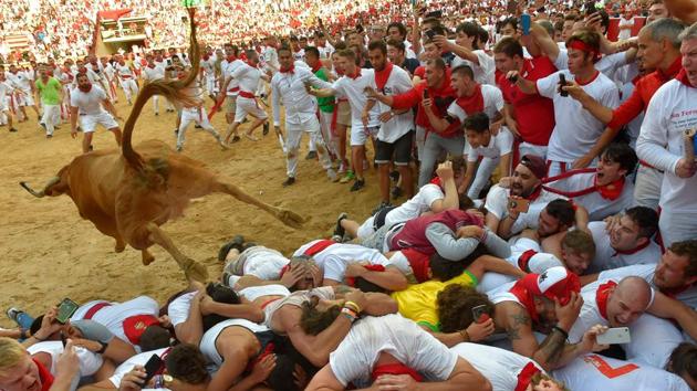 A heifer bull jumps over revelers in the bullring after the second bullrun at the San Fermin festival in Pamplona, northern Spain. On each day of the festival six bulls are released at 8:00 a.m. (0600 GMT) to run from their corral through the narrow, cobbled streets of the old town over an 850-meter (yard) course. Ahead of them are the runners, who try to stay close to the bulls without falling over or being gored. (Ander Gillenea / AFP)