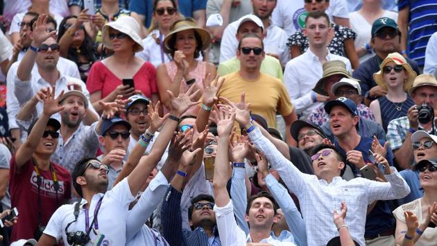 Spectators try to catch a wristband thrown by Serbia’s Novak Djokovic after winning his quarter final match against Belgium’s David Goffin, at All England Lawn Tennis and Croquet Club, London, England. (David Goffin / REUTERS)