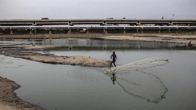 A man casts a fishing net in the depleted Porur Lake. The administration of Prime Minister Narendra Modi, who promised an ambitious healthcare expansion ahead of his re-election in May, announced a water conservation awareness program on July 1. Yet it’s unclear if the measures will be enough to ensure a steady supply of clean water. (Dhiraj Singh / Bloomberg)
