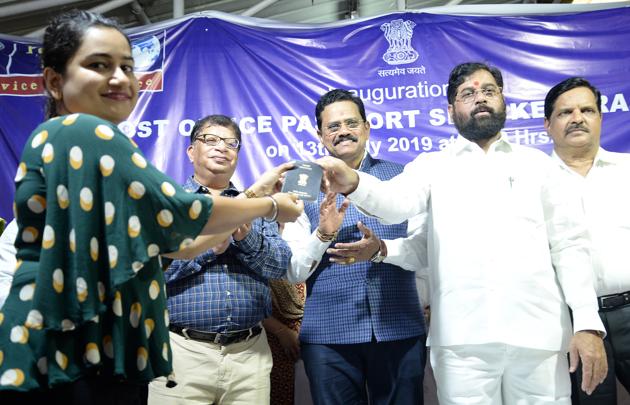 A resident receives her passport from Thane guardian minister Eknath Shinde after the inauguration of the new passport office at Vashi Post Office on Saturday.(Bachchan Kumar/HT)