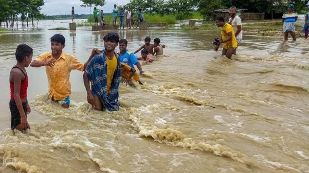 Bihar floods: Villagers wade through an area flooded by Menchi river in Kishanganj district on Friday. (PTI Photo) Bihar floods: Villagers wade through an area flooded by Menchi river in Kishanganj district on Friday. (PTI Photo)