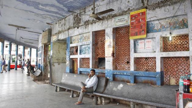 A man speaks on the phone at the inter-state bus terminal. The front facade of the bus stand is lined with empty rooms which once served as counters for booking tickets and making inquiries. These were vacated soon after the PWD survey, due to the risks posed. (Yogendra Kumar / HT Photo)