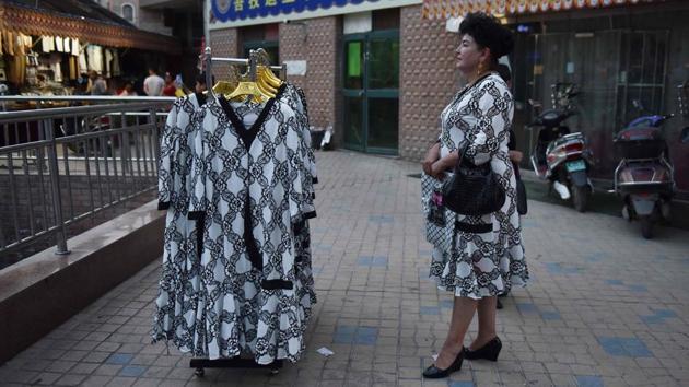 A Uighur vendor waiting for customers for her dresses outside a market in Kashgar. A traveller from Southeast Asia, who requested anonymity due to fear of reprisals, said, “They want to separate travellers from locals,” adding that his visit to Xinjiang confirmed what he had read about re-education camps. He added: “There’s a lot more of Xinjiang that I want to discover. But I really hope that Xinjiang will become the old Xinjiang.” (Greg Baker / AFP) A Uighur vendor waiting for customers for her dresses outside a market in Kashgar. A traveller from Southeast Asia, who requested anonymity due to fear of reprisals, said, “They want to separate travellers from locals,” adding that his visit to Xinjiang confirmed what he had read about re-education camps. He added: “There’s a lot more of Xinjiang that I want to discover. But I really hope that Xinjiang will become the old Xinjiang.” (Greg Baker / AFP)