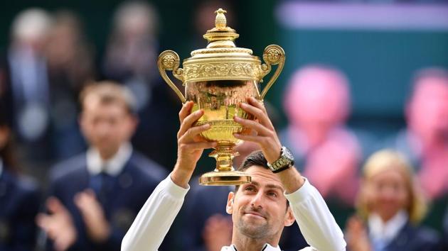 Serbia's Novak Djokovic raises the winner's trophy after beating Switzerland's Roger Federer(AFP)