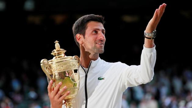 Novak Djokovic poses with the trophy as he celebrates winning the final against Roger Federer.(REUTERS)