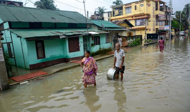 Residents wade through a flooded street following heavy monsoon rains, in Guwahati, Tuesday, July 16, 2019. The water level of River Brahmaputra has risen above the danger level causing flood like situation in many areas. (Photo: PTI) Residents wade through a flooded street following heavy monsoon rains, in Guwahati, Tuesday, July 16, 2019. The water level of River Brahmaputra has risen above the danger level causing flood like situation in many areas. (Photo: PTI)
