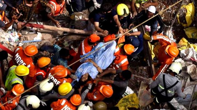 Indian National Disaster Response Force and Indian fire brigade personnel rescue a survivor from after a building collapsed in Mumbai on July 16, 2019.(Photo: Kunal Patil/ HT)