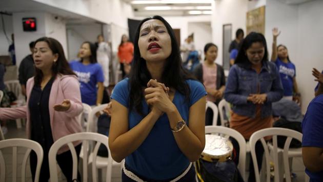 Merry Christ Palacios, 37, a caregiver from Philippines, prays during a church service held at the bus station. She also shops at the station. “It’s special because I can find everything we need to buy,” she said, but added visitors need to be “very careful about their bag, cellphone, money and things” as they navigate the station’s hallways. (Corinna Kern / REUTERS) Merry Christ Palacios, 37, a caregiver from Philippines, prays during a church service held at the bus station. She also shops at the station. “It’s special because I can find everything we need to buy,” she said, but added visitors need to be “very careful about their bag, cellphone, money and things” as they navigate the station’s hallways. (Corinna Kern / REUTERS)