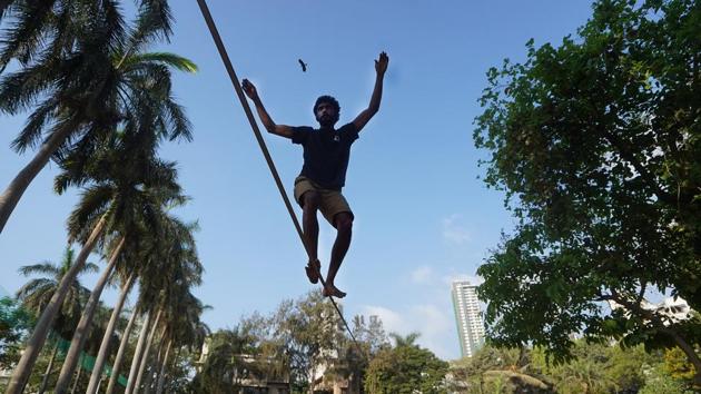 Farooqui practises slacklining at a park in Wadala, Mumbai. Slacklines are tensioned significantly less than tightropes or tightwires in order to create a dynamic line which will stretch and bounce like a long and narrow trampoline. Tension can be adjusted to suit the user, and different webbing may be used in various circumstances. (Hemanshi Kamani / HT Photo) 