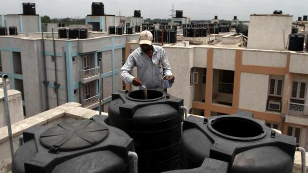 An MCD worker puts medicine in open water tanks.(HT File Photo)