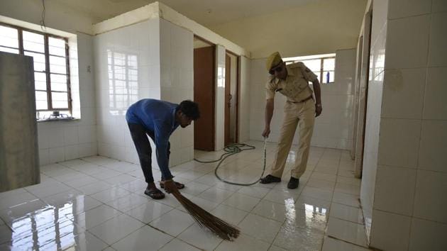 A police personnel helps a worker to clean a washroom at the station. Om Prakash, a sanitation worker from Nathusar village, said when he was asked by a policeman to clean up the station last winter, he was prepared to not get paid. “I couldn’t believe it when the police gave me Rs. 200 for a few hours of work,” said Prakash, who now works at the police station. (Biplov Bhuyan / HT Photo) A police personnel helps a worker to clean a washroom at the station. Om Prakash, a sanitation worker from Nathusar village, said when he was asked by a policeman to clean up the station last winter, he was prepared to not get paid. “I couldn’t believe it when the police gave me Rs. 200 for a few hours of work,” said Prakash, who now works at the police station. (Biplov Bhuyan / HT Photo)